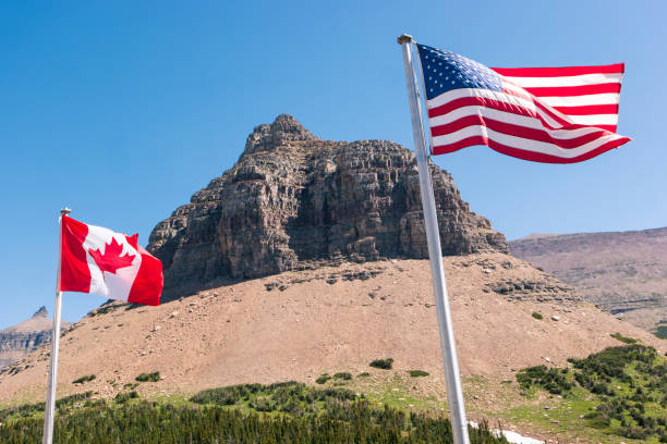 istock Pollock Mountain, Logan Pass, American and Canadian flag 1016659112