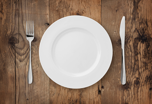 Table setting on rustic wood background - plate, fork and knife