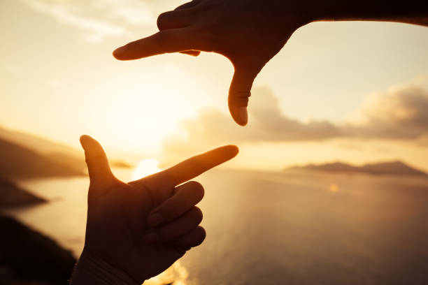 istock Two hands making a picture frame in sunrise sky 1016673242