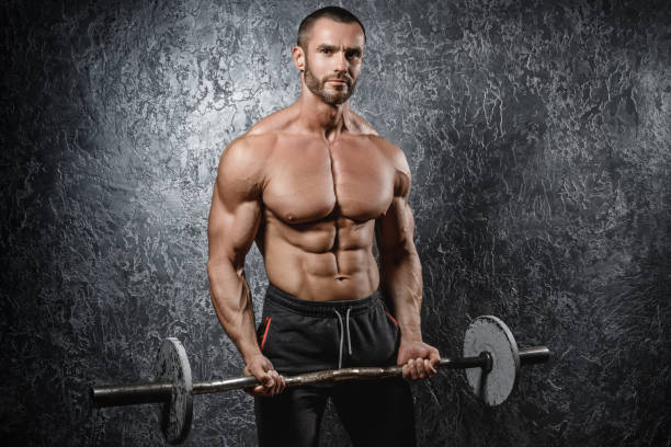 istock Muscular bodybuilder exercising with a barbell 1016684796