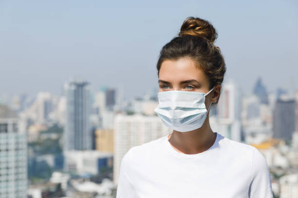 Air pollution or virus epidemic in the city Woman wearing face mask because of Air pollution or virus epidemic in the city weather protection clothing stock pictures, royalty-free photos & images