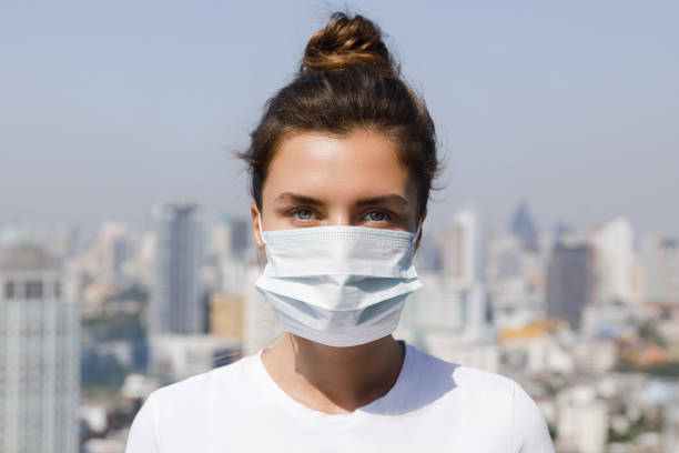 Air pollution or virus epidemic in the city Woman wearing face mask because of Air pollution or virus epidemic in the city weather protection clothing stock pictures, royalty-free photos & images