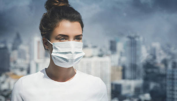 Air pollution in the city Woman wearing face mask because of air pollution in the city weather protection clothing stock pictures, royalty-free photos & images