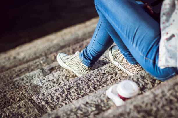 A closeup shot of a girl in stylish pink sneakers standing on a street
