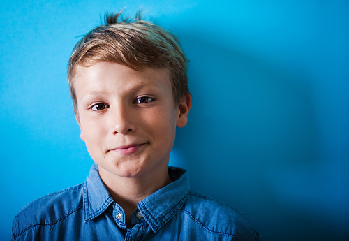 Happy boy portrait on a blue background