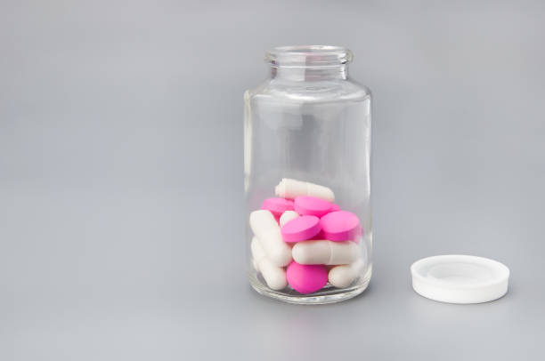 istock Large and bright red and white pills in a glass jar. 1016692740