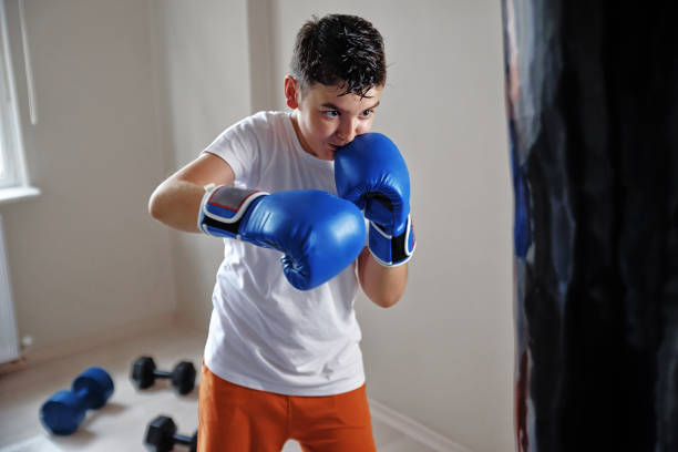 istock Child training boxing with punching bag 1016712118
