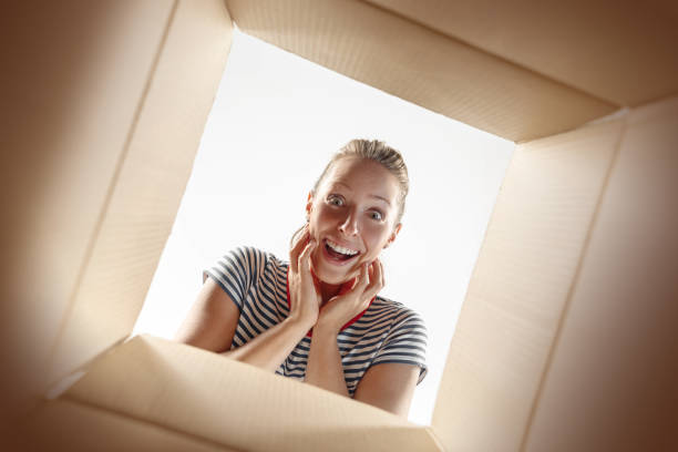 istock Woman unpacking and opening carton box and looking inside 1016715894