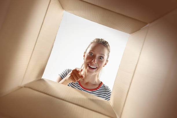 istock Woman unpacking and opening carton box and looking inside 1016715932
