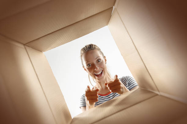 istock Woman unpacking and opening carton box and looking inside 1016716210