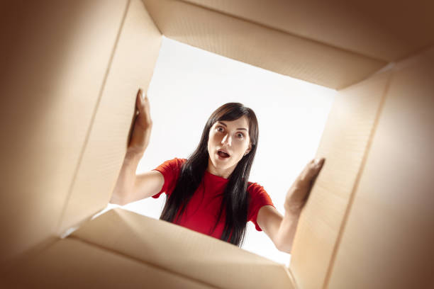 istock Woman unpacking and opening carton box and looking inside 1016720268