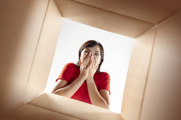 istock Woman unpacking and opening carton box and looking inside 1016720360