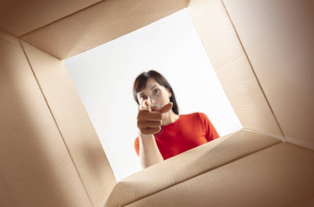 istock Woman unpacking and opening carton box and looking inside 1016720440