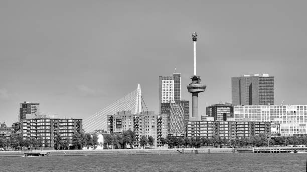 Black and white image of the skyline of Rotterdam, the Netherlands, seen over water. With the Euromast tower and some other famous buildings in the distance.