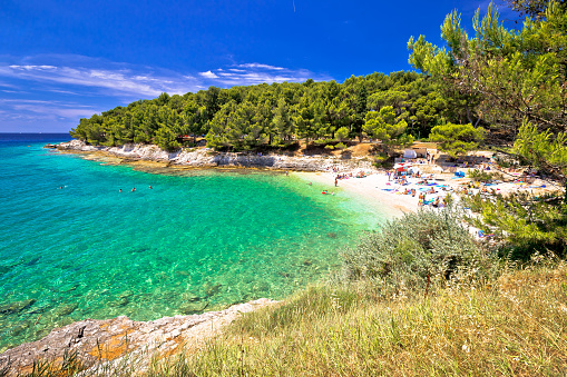 Idyllic turquoise beach in Pula summer view, blurred people, Istria region of Croatia
