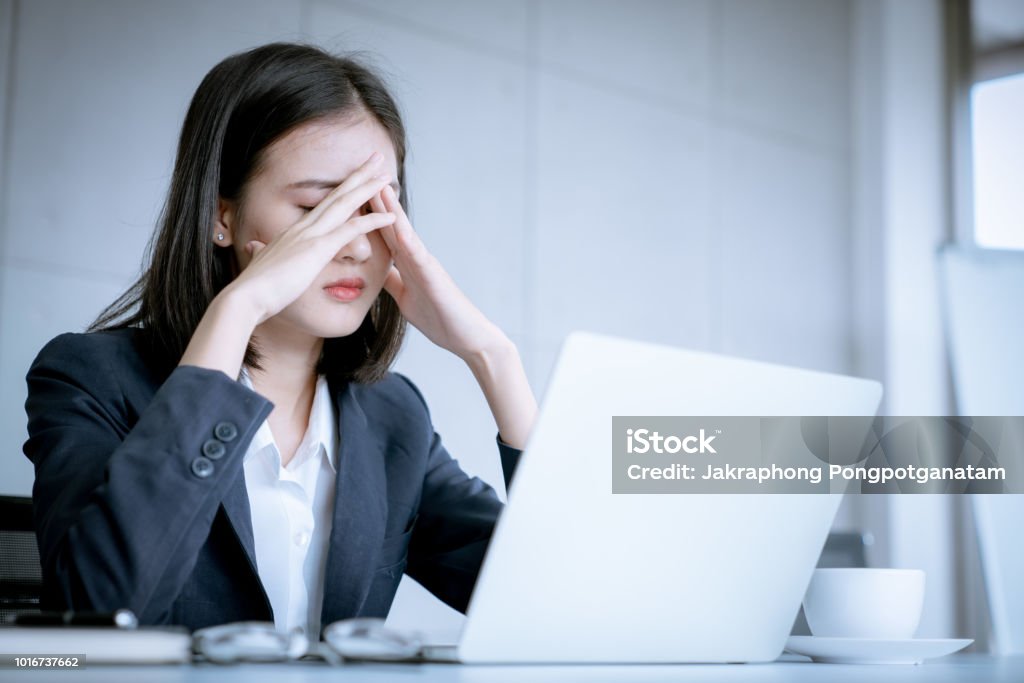 Asian business woman headache stressed because of work mistake problems about profit losses to be risk for fired from her job Women Stock Photo