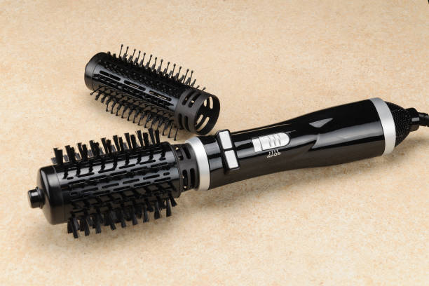 Black brush hair dryer on the marble background with accessory