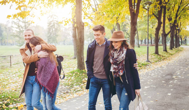 istock Two friend couples walking in a park 1016740980