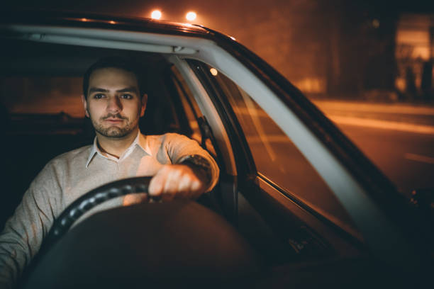 istock Young man driving car at night 1016761658