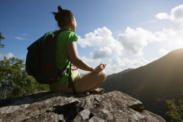 istock Successful woman hiker meditation on mountain top cliff edge 1016764388