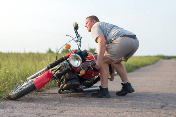 istock A man lifts a motorcycle that fell after an accident 1016769034