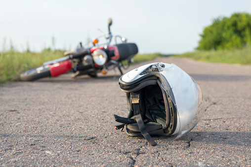 Foto del casco y de la motocicleta en la carretera, el concepto de accidentes de photo