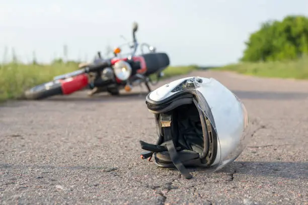 Photo of Photo of helmet and motorcycle on the road, the concept of road accidents