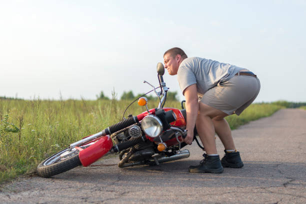 istock A man lifts a motorcycle that fell after an accident 1016769396
