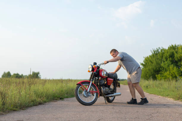 um homem fica perto da motocicleta em um dia claro de verão - biker macho men rough - fotografias e filmes do acervo