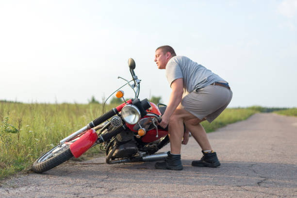 istock A man lifts a motorcycle that fell after an accident 1016771616
