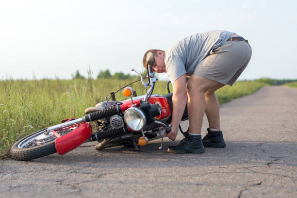 istock A man lifts a motorcycle that fell after an accident 1016771696