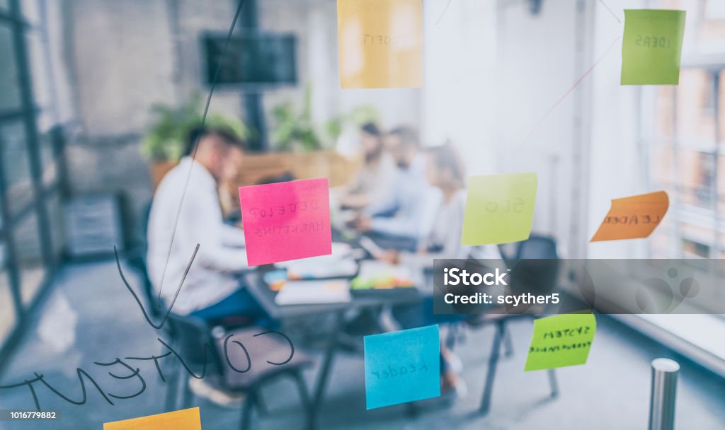 Young creative business people meeting at office. Business people meeting at office and use post it notes to share idea. Brainstorming concept. Sticky note on glass wall. Education Training Class Stock Photo