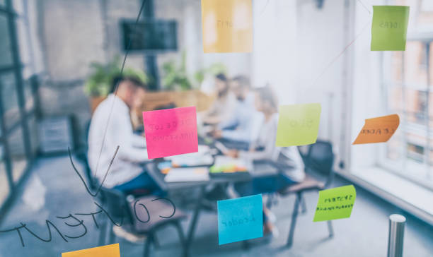 Young creative business people meeting at office. Business people meeting at office and use post it notes to share idea. Brainstorming concept. Sticky note on glass wall. market research photos stock pictures, royalty-free photos & images