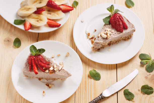 raw vegan cheesecake with strawberry and banana - cheesecake syrup almond cream imagens e fotografias de stock