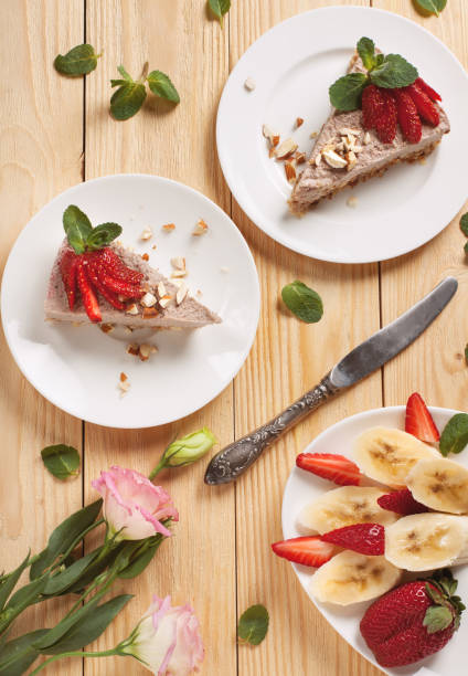 raw vegan cheesecake with strawberry and banana - cheesecake syrup almond cream imagens e fotografias de stock