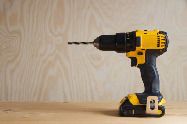 istock cordless drill against wooden background, rechargeable drill 1016788330