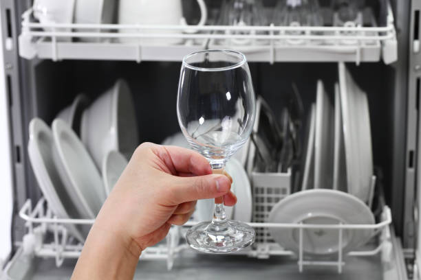 open dishwasher, man hand taking out clean wine glass, after washing dishwasher, open and loaded with dishes, man hand taking out clean wine glass, after washing dishwasher stock pictures, royalty-free photos & images