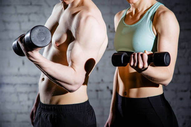 istock Strong young couple working out with dumbbells. Shot in studio on a white background 1016807298