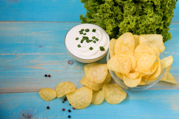 istock Crispy potato chips in a glass bowl with sour cream 1016818908