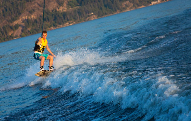 wakeboard maschile per giovani adulti sul lago okanagan - life jacket little boys lake jumping foto e immagini stock