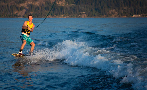 jeune adulte wakeboard mâle sur le lac okanagan - life jacket little boys lake jumping photos et images de collection