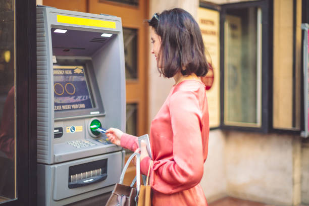 istock Young woman is withdrawing cash from an atm machine 1016831768