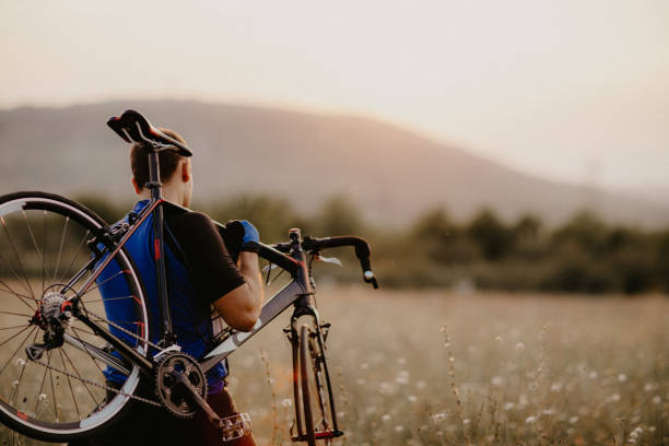 Well built man carrying his bike