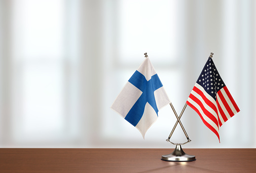 Two crossed national flags on wooden table