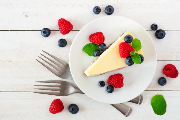 istock Cheesecake with blueberries and raspberries, top view over white wood 1016858860
