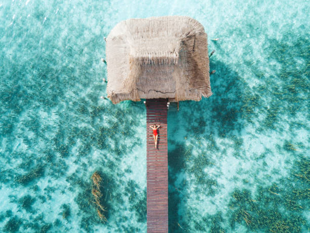 toma aérea de womann relajante en un bungalow de agua - travel luxury aerial view beach fotografías e imágenes de stock