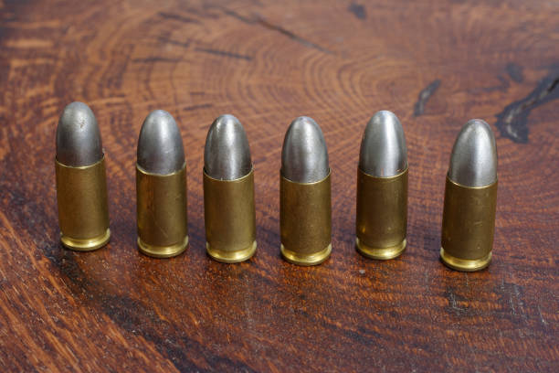 istock 9mm caliber cartridges on wooden background 1016884894