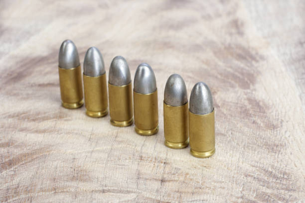 istock 9mm caliber cartridges on wooden background 1016884930