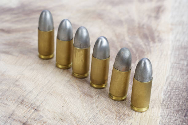 istock 9mm caliber cartridges on wooden background 1016884960