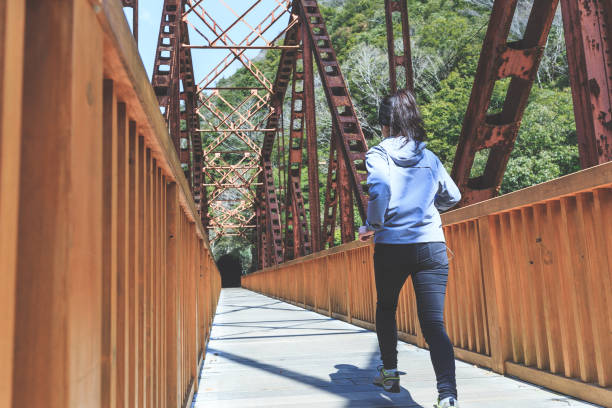 istock Asian lady running on the iron bridge 1016909742